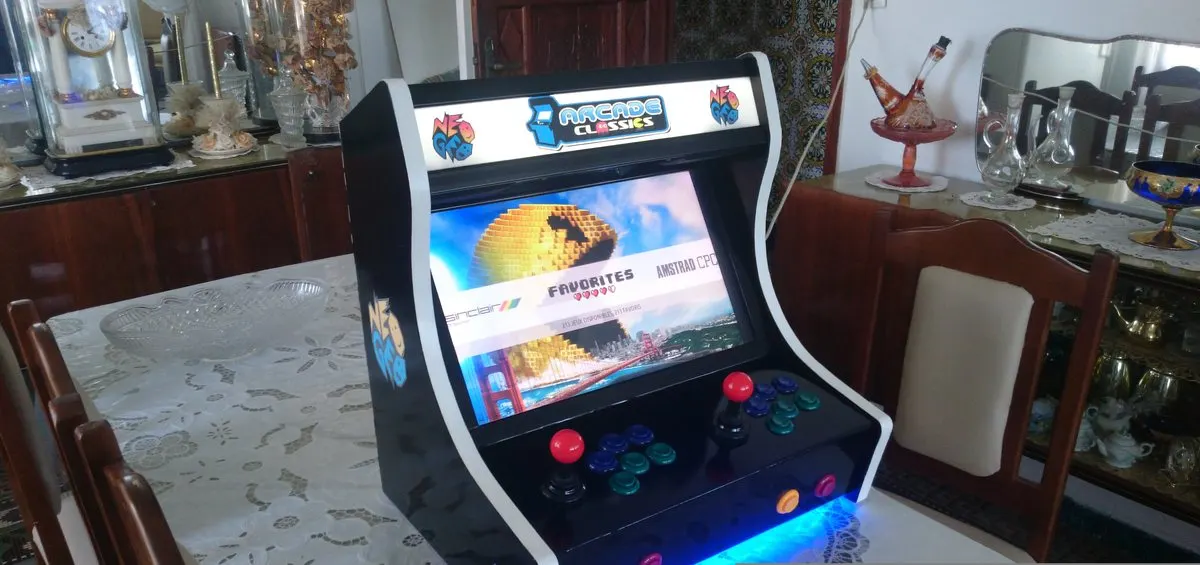 A home-built bartop arcade cabinet with a joystick and buttons sitting on a dining table